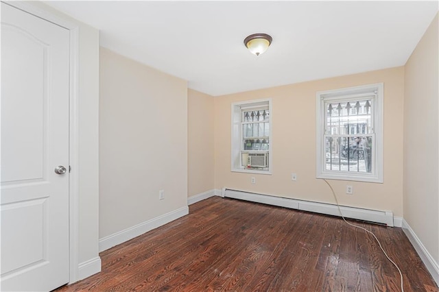 spare room with dark wood-style floors, baseboards, baseboard heating, and cooling unit