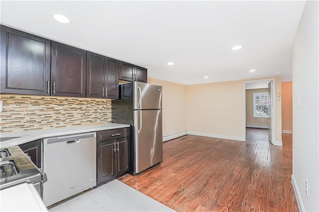 kitchen with baseboard heating, light countertops, backsplash, and appliances with stainless steel finishes