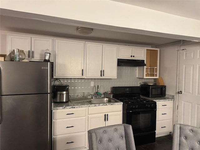 kitchen featuring sink, black appliances, light stone countertops, and backsplash