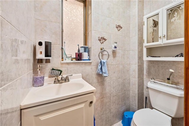 half bathroom with decorative backsplash, toilet, tile walls, and vanity