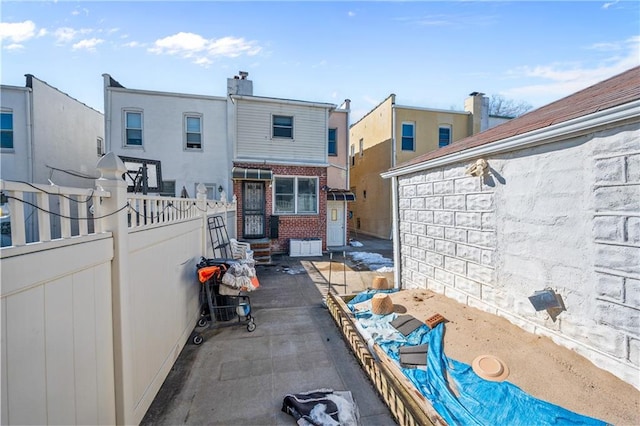 exterior space featuring brick siding and fence