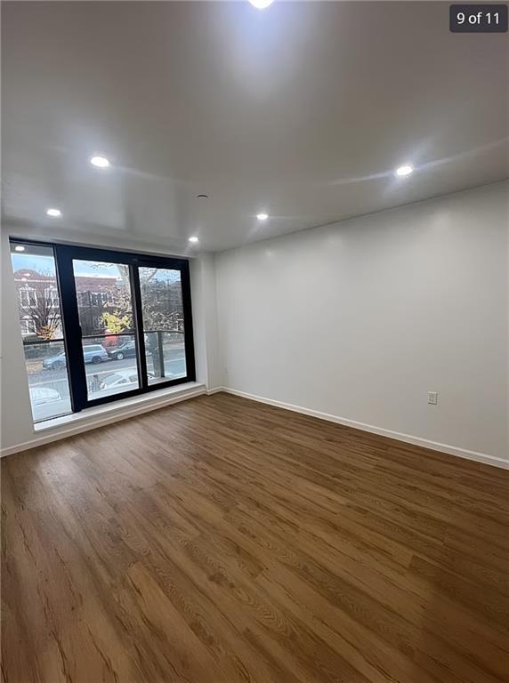 unfurnished room featuring wood finished floors, baseboards, and recessed lighting