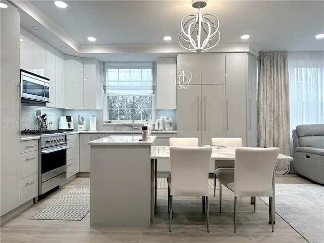 40 Oceana Dr W Unit 2G, Brooklyn, NY 11235 - kitchen with stainless steel appliances, modern cabinets, a sink, a chandelier, and hanging light fixtures