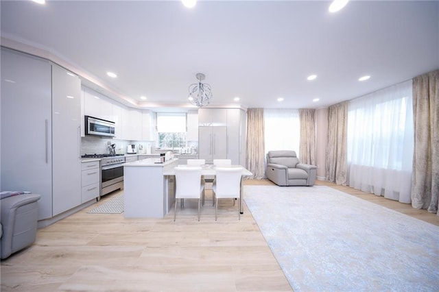 40 Oceana Dr W Unit 2G, Brooklyn, NY 11235 - kitchen with stainless steel appliances, open floor plan, white cabinets, a kitchen island, and recessed lighting