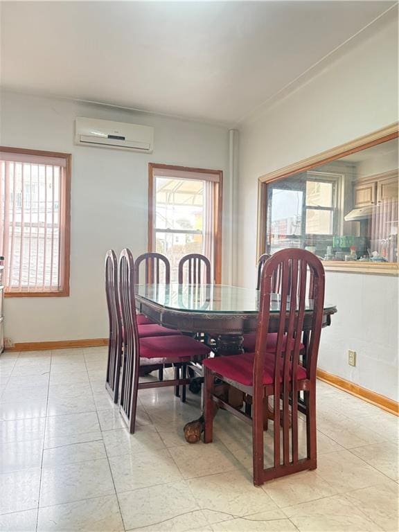 dining room with baseboards, a healthy amount of sunlight, a wall mounted AC, and light tile patterned floors