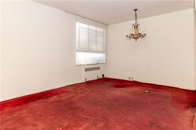 carpeted empty room with radiator and a notable chandelier