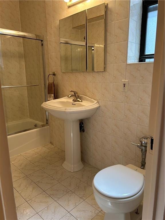 110 Shore Blvd Unit 4H, Brooklyn, NY 11235 - bathroom with tile walls, tile patterned floors, toilet, and bath / shower combo with glass door