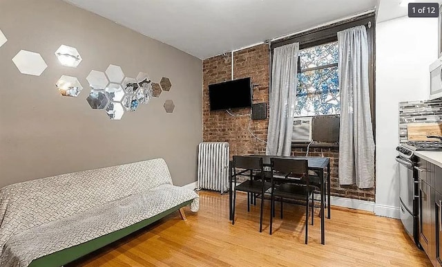 dining area featuring light wood-style floors and radiator