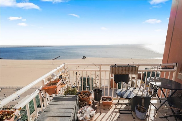 balcony featuring a water view and a view of the beach