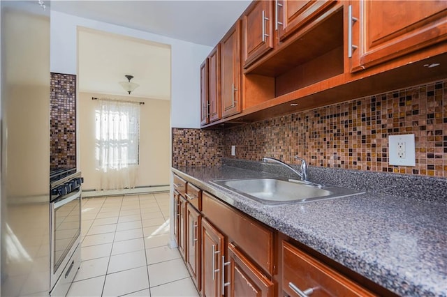 kitchen featuring sink, oven, decorative backsplash, light tile patterned floors, and baseboard heating