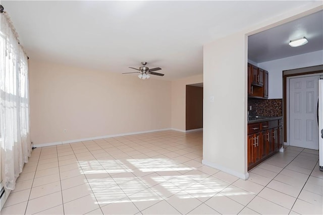 interior space featuring light tile patterned floors, backsplash, and ceiling fan