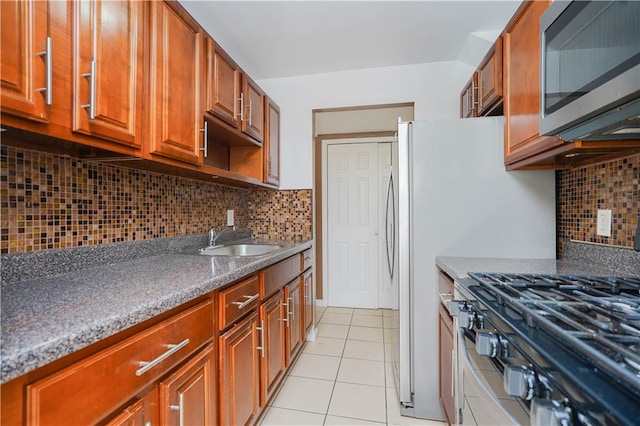 kitchen featuring light tile patterned flooring, stove, sink, and decorative backsplash