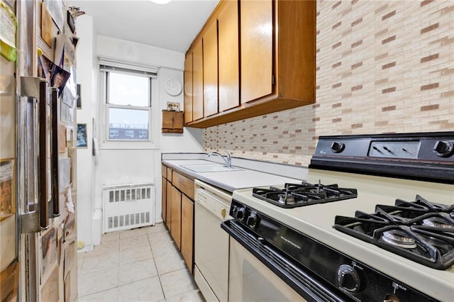 kitchen with radiator, range with gas stovetop, sink, backsplash, and dishwasher