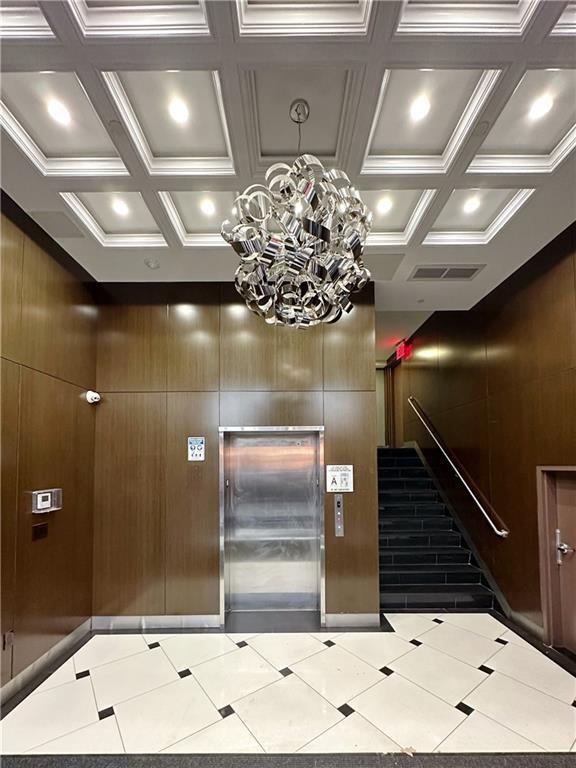 reception area featuring stairs, visible vents, and a notable chandelier