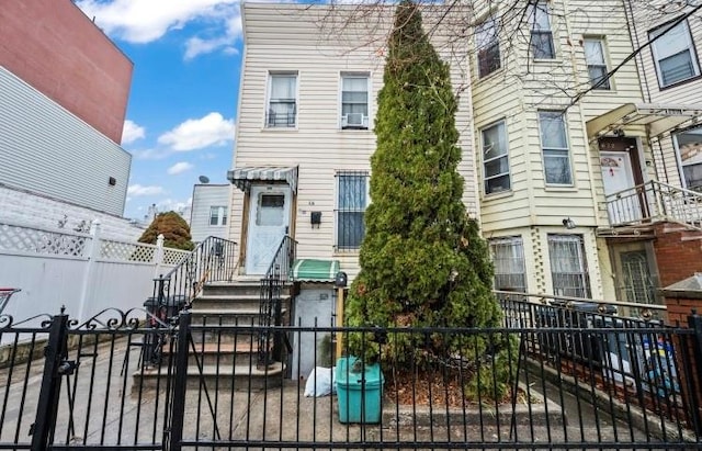 townhome / multi-family property featuring a fenced front yard and a gate