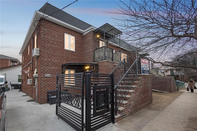 view of front of home featuring a shingled roof and brick siding