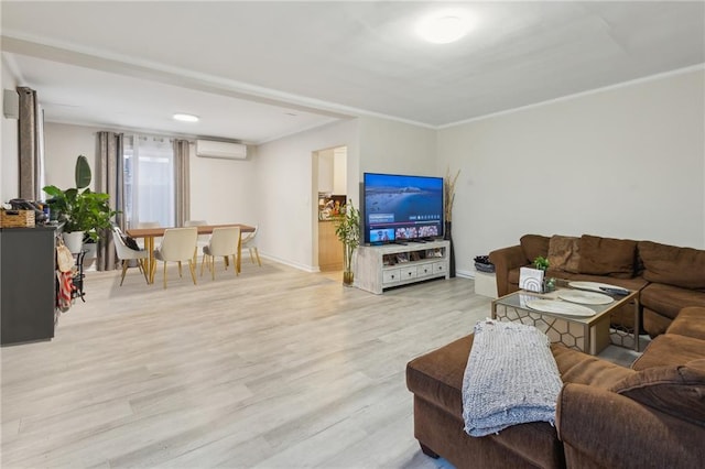 living room featuring ornamental molding, light wood-style flooring, baseboards, and a wall mounted AC