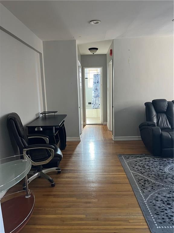 hall with baseboards and wood finished floors