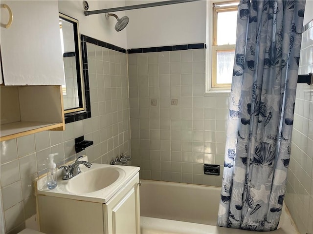bathroom with tile walls, shower / bathtub combination with curtain, decorative backsplash, and vanity