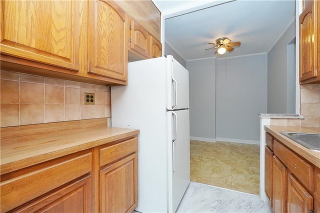 kitchen with butcher block countertops, decorative backsplash, a ceiling fan, and freestanding refrigerator