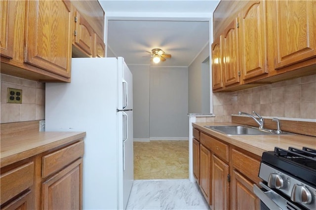 kitchen with a ceiling fan, stainless steel range with gas cooktop, light countertops, and freestanding refrigerator