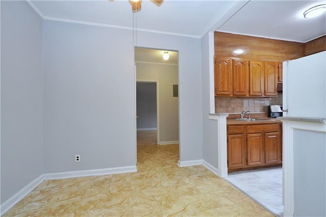 kitchen featuring ornamental molding, a sink, ceiling fan, and decorative backsplash