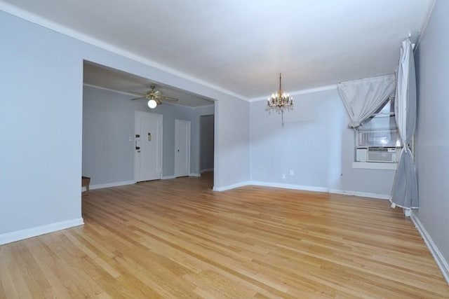 spare room featuring ceiling fan with notable chandelier, light wood finished floors, and baseboards