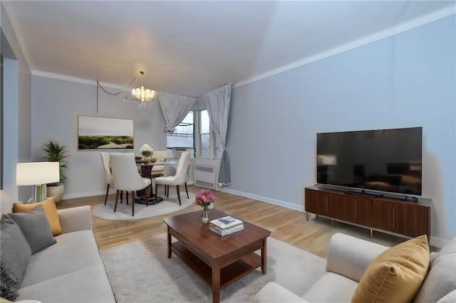 living area with a chandelier, baseboards, and wood finished floors