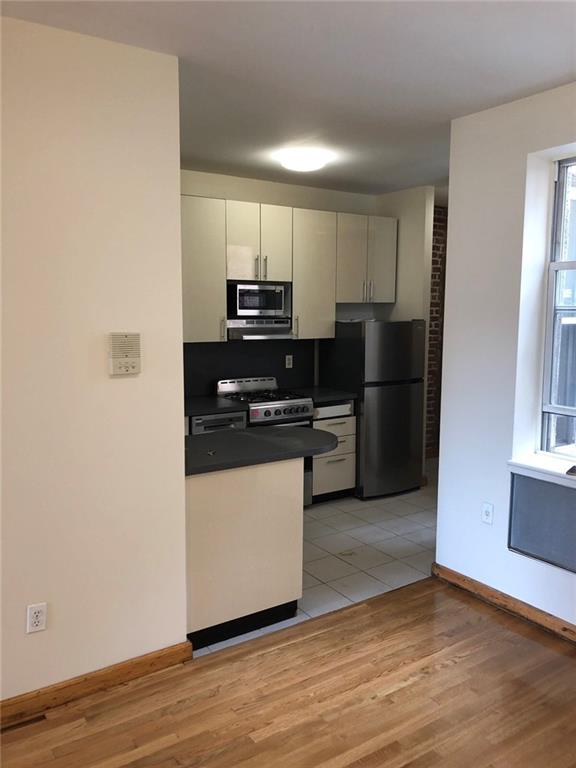 kitchen featuring white cabinets, stainless steel appliances, and light hardwood / wood-style floors