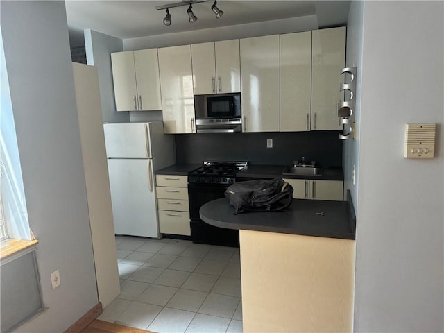 kitchen with light tile patterned floors, sink, black appliances, cream cabinets, and decorative backsplash