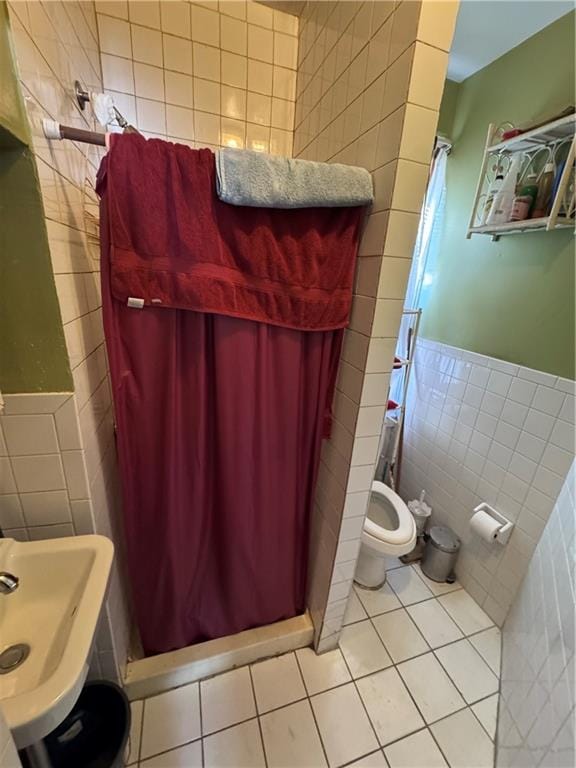 bathroom featuring tile walls, toilet, tile patterned floors, and walk in shower