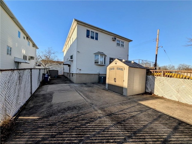 rear view of house with a shed and central air condition unit