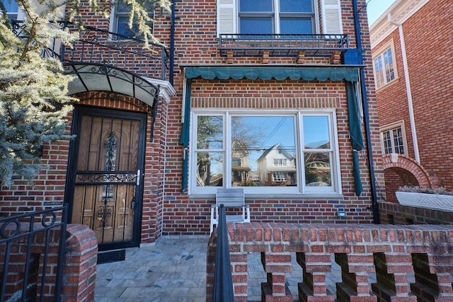 view of exterior entry featuring brick siding