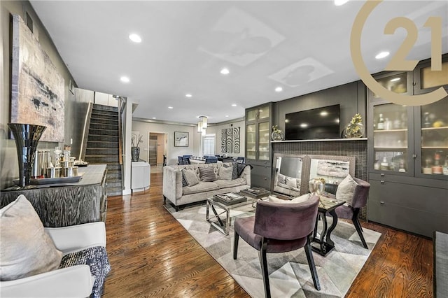 living room with a fireplace, stairway, wood finished floors, and recessed lighting