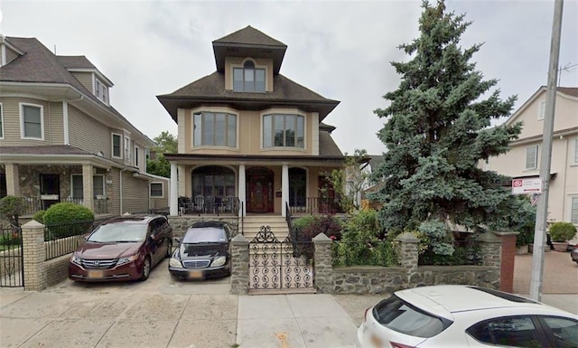 view of front of house featuring a porch and a fenced front yard