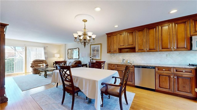 dining room with light hardwood / wood-style floors and an inviting chandelier