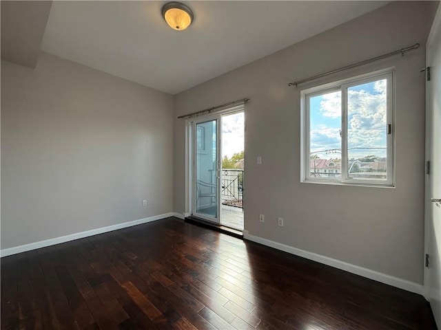 unfurnished room with dark wood-type flooring and baseboards