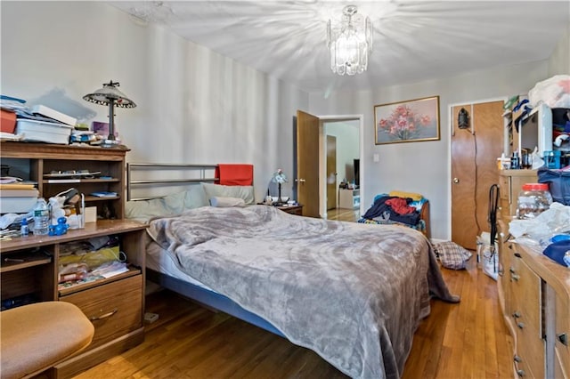 bedroom featuring hardwood / wood-style flooring and a notable chandelier