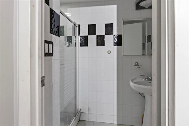 bathroom featuring baseboard heating, tile walls, and a shower with door