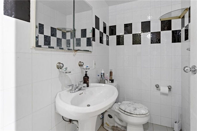 bathroom with tile walls, sink, and toilet