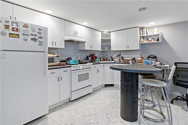 kitchen with sink, white appliances, white cabinetry, and a breakfast bar