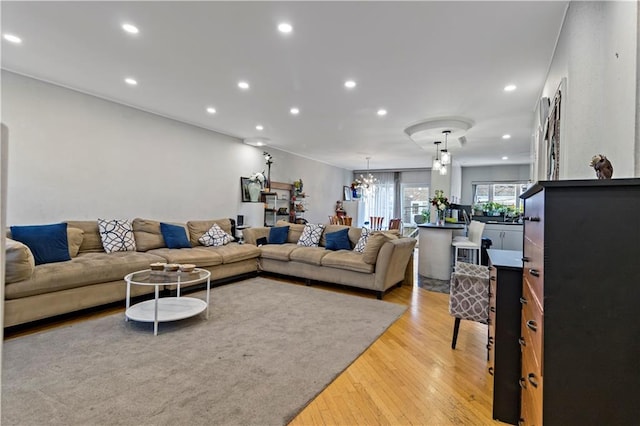 living room with light hardwood / wood-style flooring and a notable chandelier