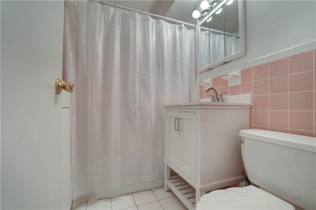 bathroom with tile walls, toilet, shower / bath combo, vanity, and tile patterned floors