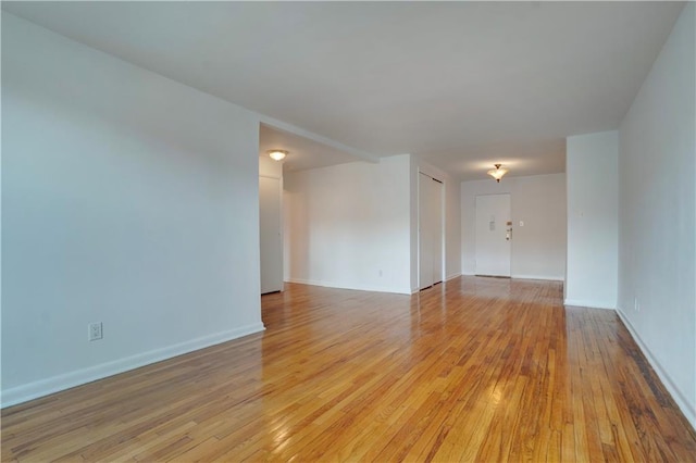 spare room featuring baseboards and light wood-style flooring