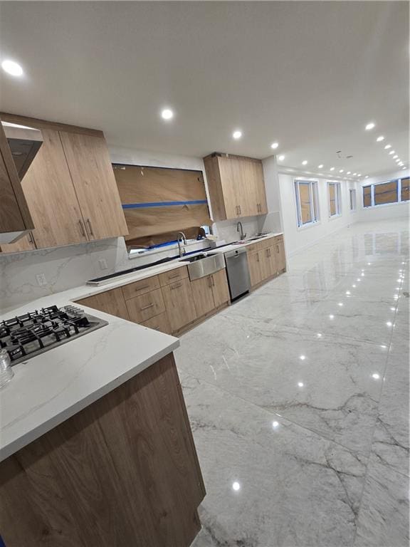 kitchen with modern cabinets, light stone countertops, marble finish floor, stainless steel appliances, and recessed lighting