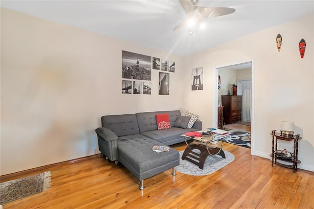 living area with a ceiling fan and wood finished floors