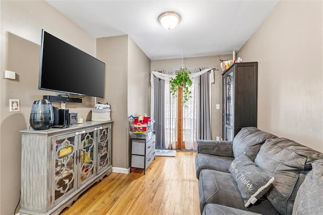 living area with light wood-style flooring and baseboards