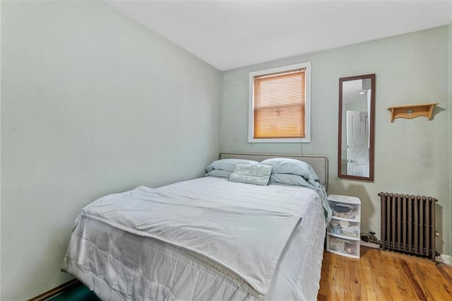 bedroom featuring radiator and light wood-style floors