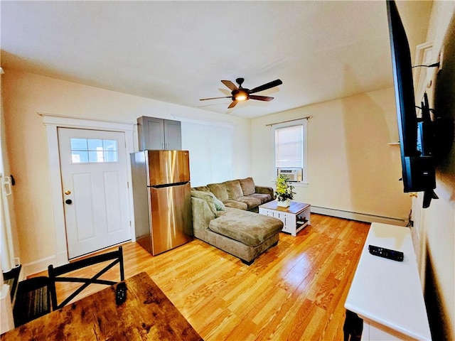 living room featuring a baseboard heating unit, plenty of natural light, light wood-style flooring, and ceiling fan