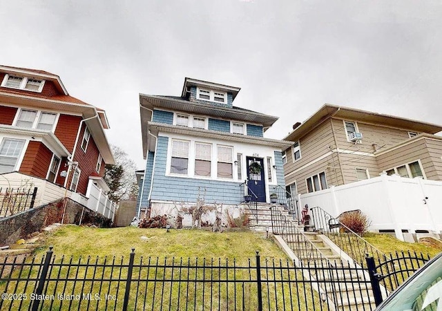 american foursquare style home with a front yard, fence, and entry steps